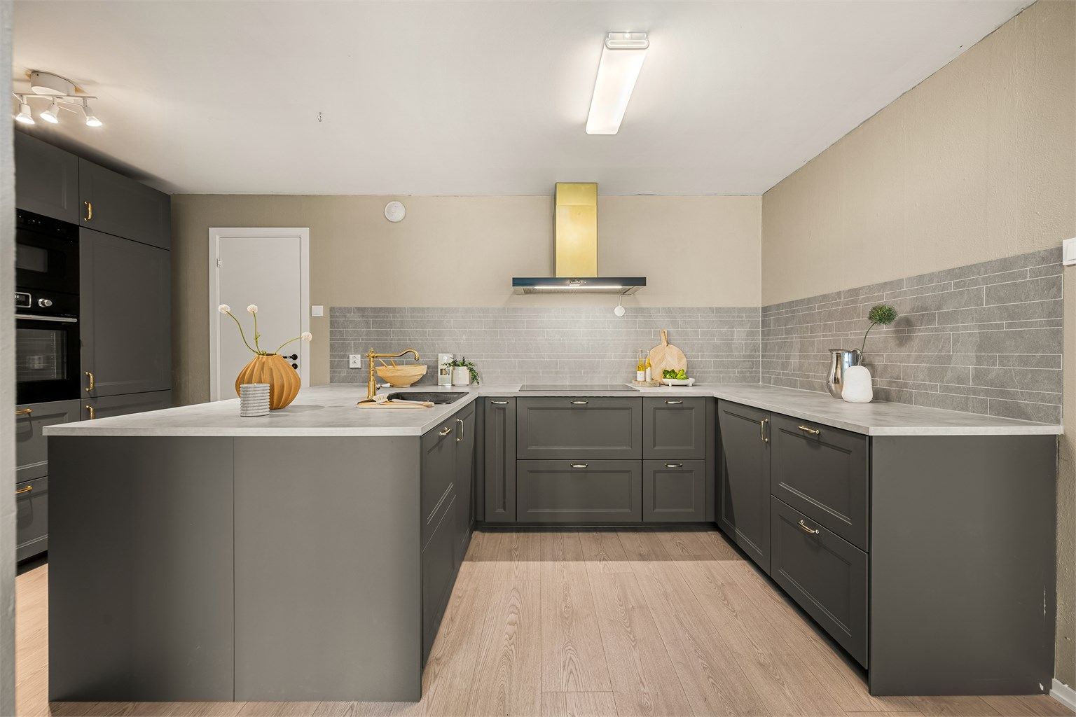 Kjøkkenet er utstyrt med integrert stekeovn, mikrobølgeovn, induksjonstopp og kjøleskap med frysedel.