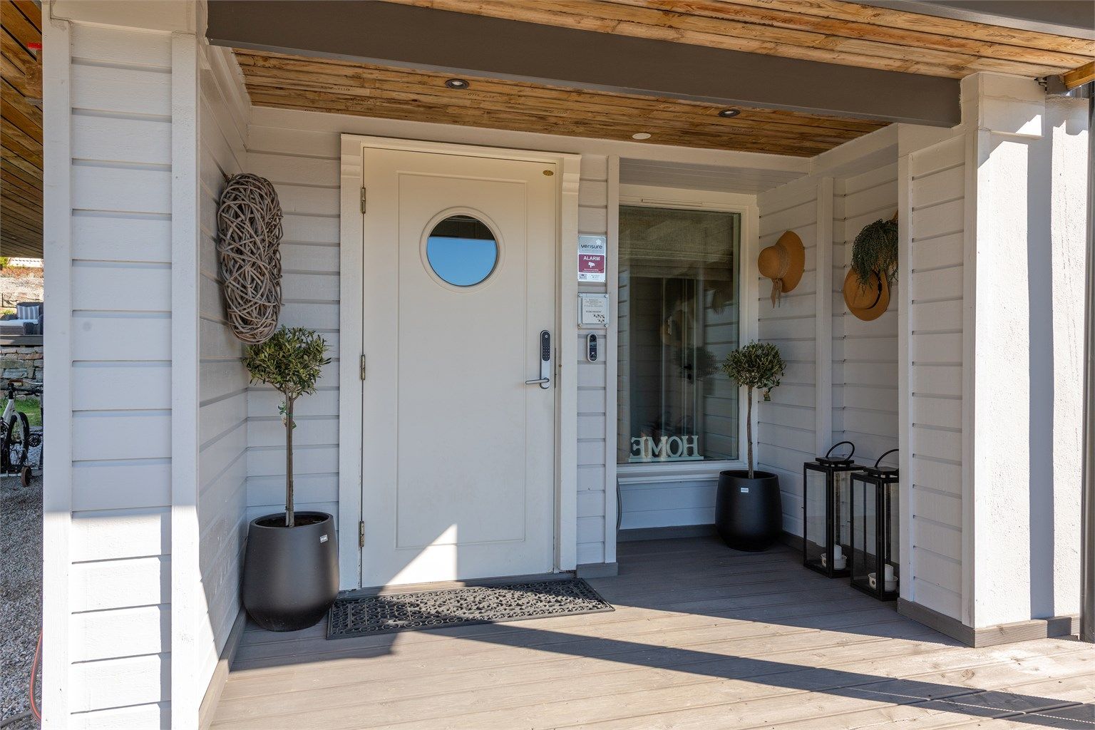 Overbygd inngangsparti med entrédør med elektrisk kodelås