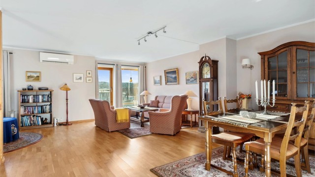 Romslig og lys stue med god plass til både sofagruppe og spisebord. Store vindusflater slipper inn rikelig med dagslys og gir rommet en luftig atmosfære.