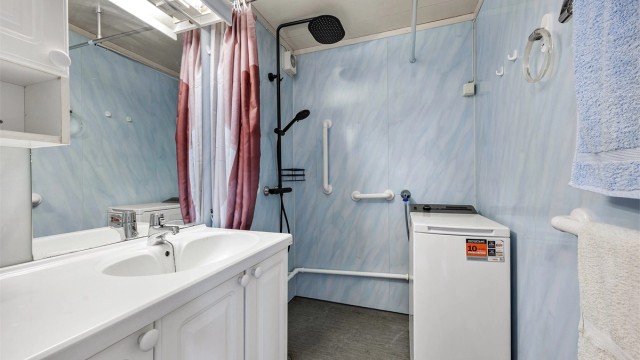 Badet i andre etasje har baderomsplater på veggene, gulvbelegg og opplegg for vaskemaskin.