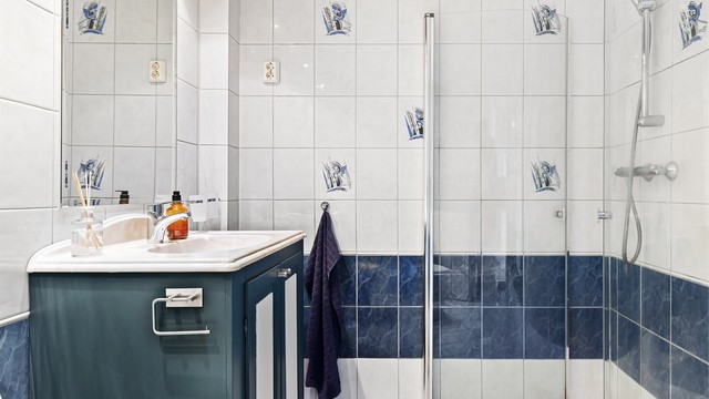 Servantinnredning med oppbevaringsplass og et vegghengt speil.