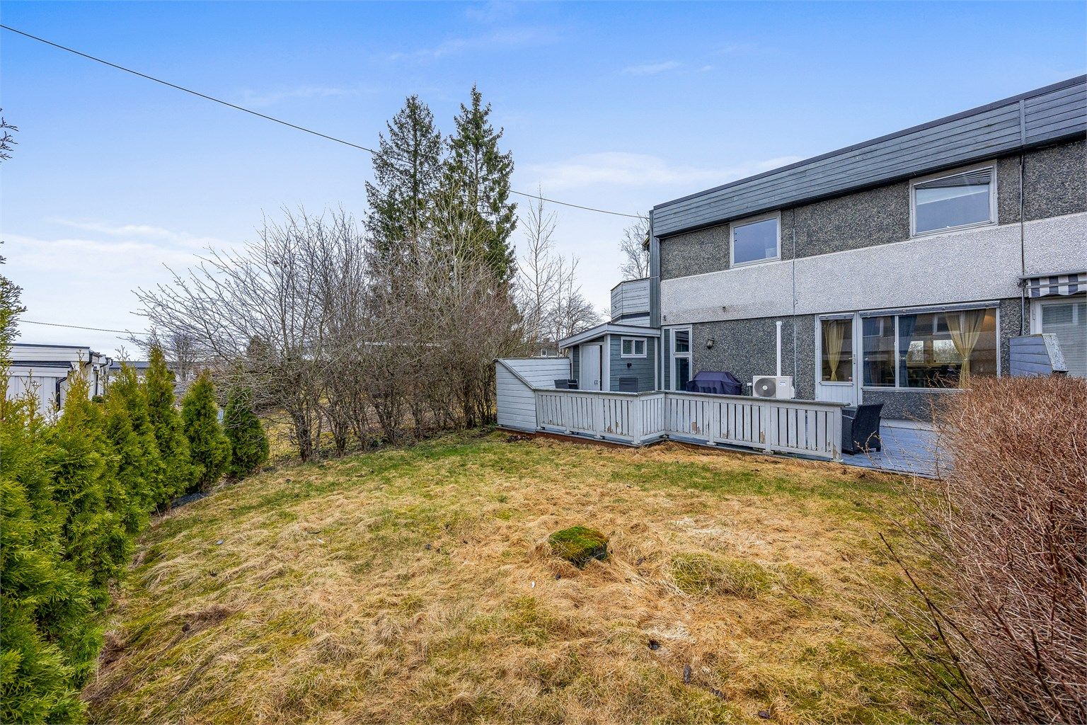 Tomten er opparbeidet med plenarealer og beplantning.