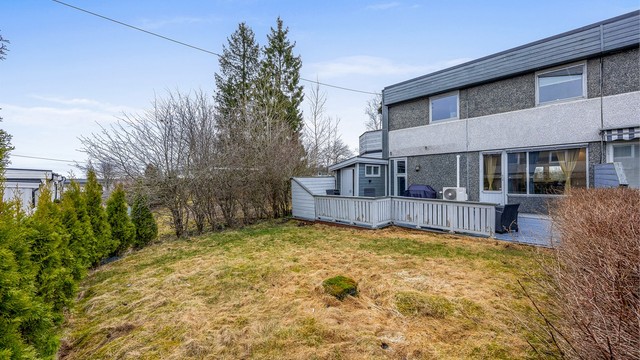 Tomten er opparbeidet med plenarealer og beplantning.