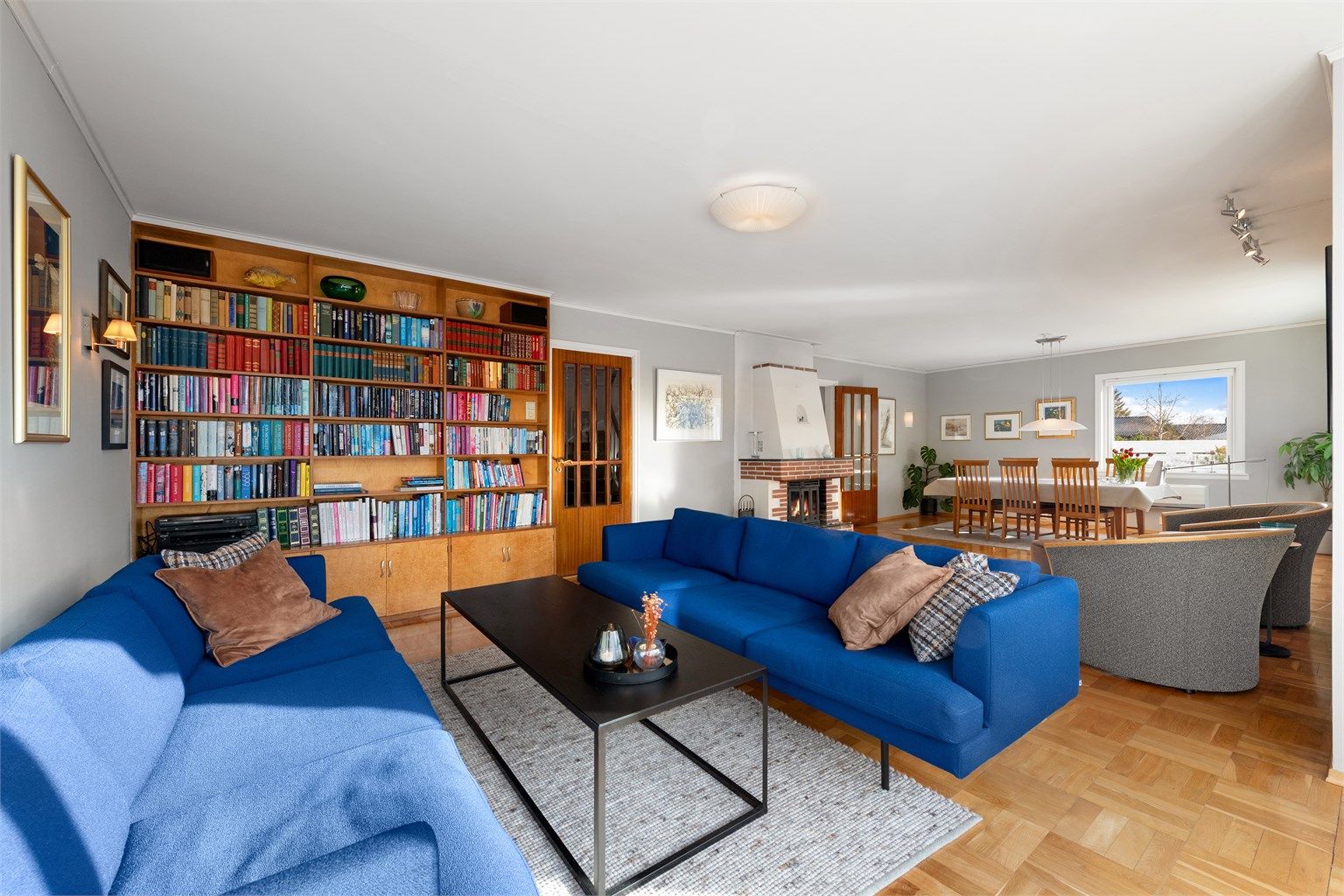 Fastmontert skap og bokhyller på ene veggen på stue