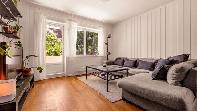 Romslig stue med peisovn og utgang til syd-vestvendt balkong.