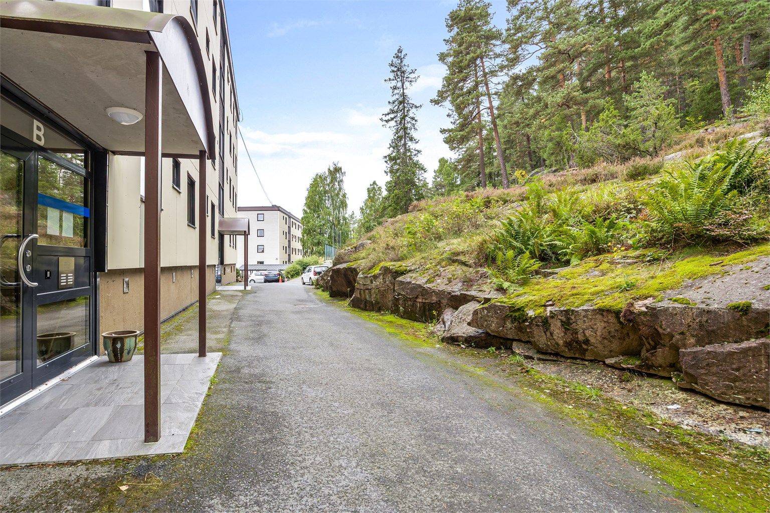 Felles overbygget inngangsparti med videre trappeadkomst til leiligheten. Leiligheten ligger i en høy 1. etasje.