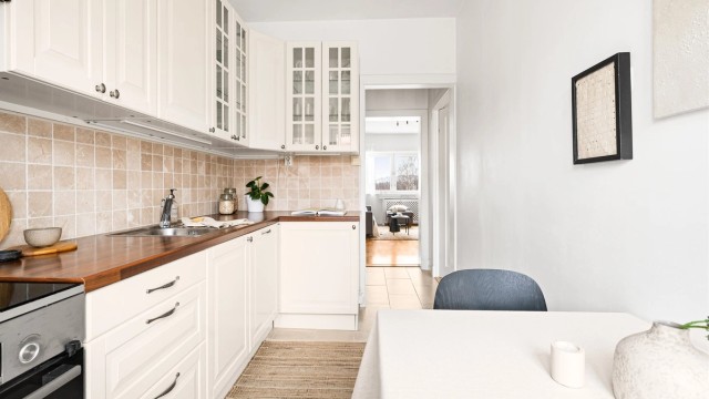 Vegger og himling er utført i malte flater. Kjøkkeninnredningen består av profilerte fronter og benkeplate i laminat, med nedfelt oppvaskkum i rustfritt stål og ettgreps armatur.