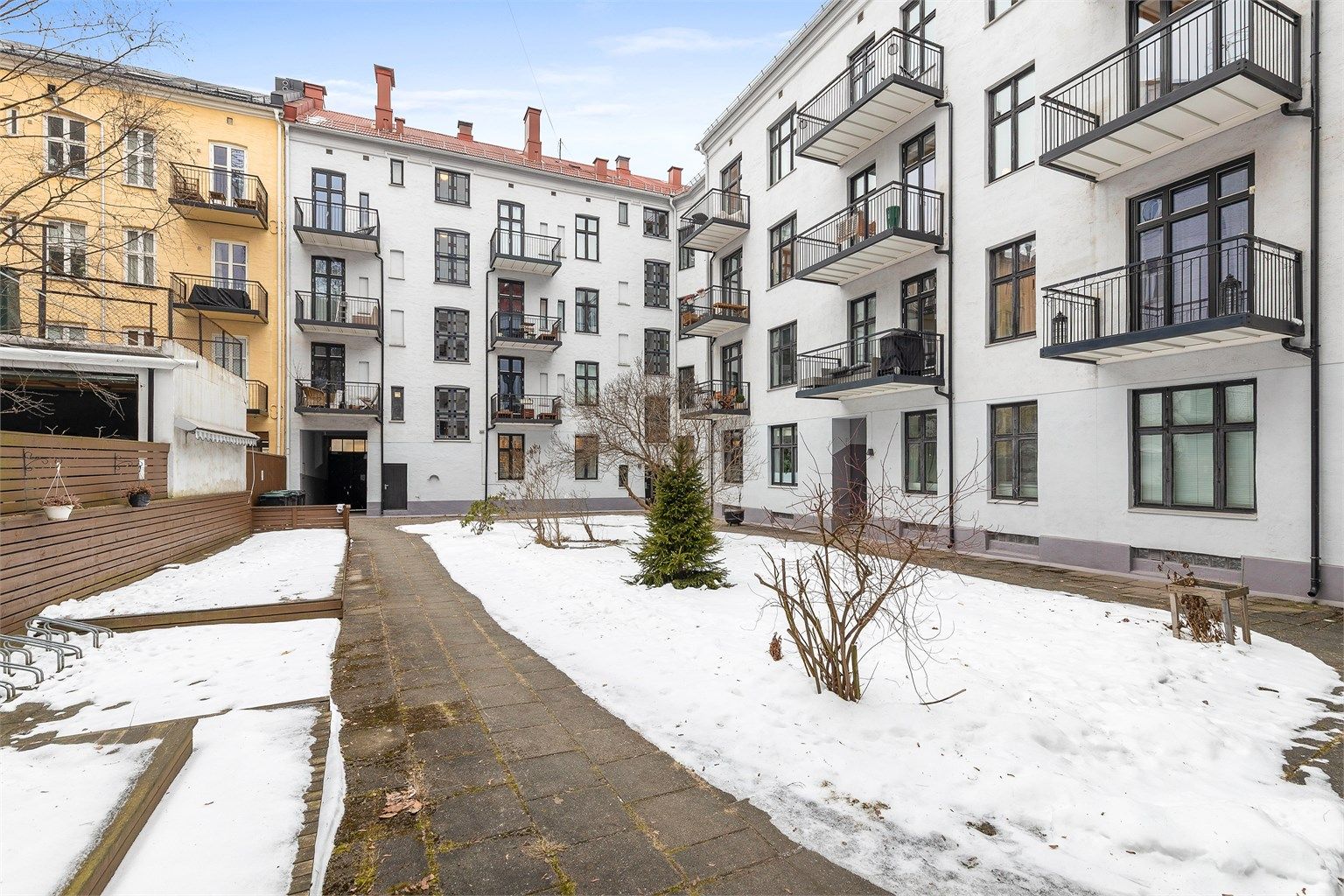 Hyggelig bakgård for borettslaget. Tomt opparbeidet med busker, trær, diverse beplantning, plenområder, sykkelparkering, hellebelagt og asfalterte internveier.