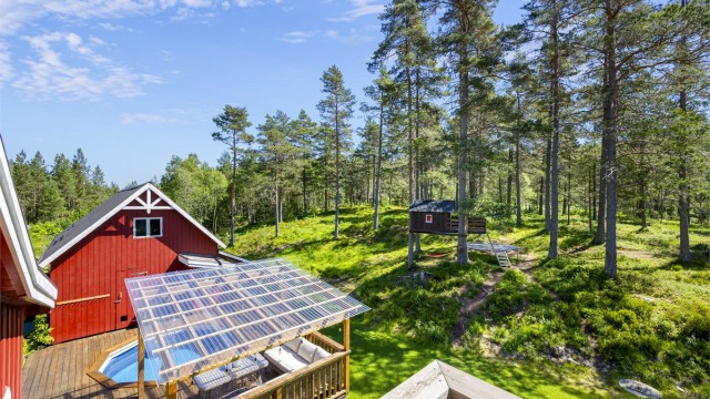 Oversikt over uteområdet med terrasse, basseng og låve.