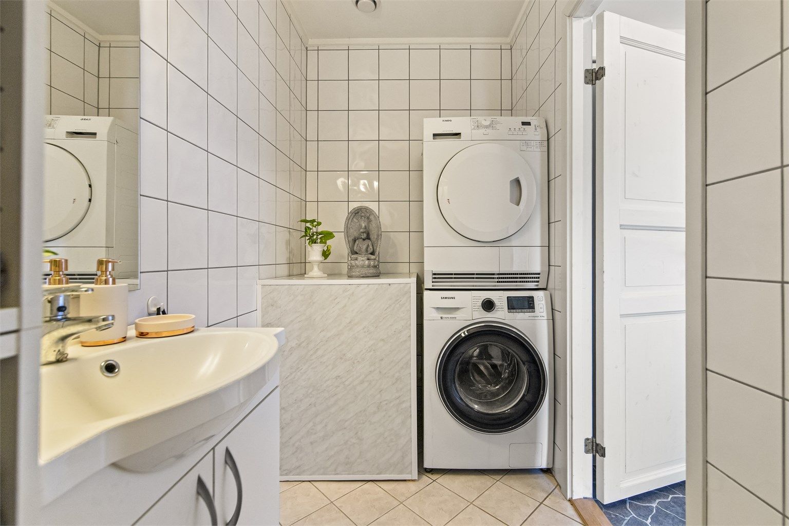 Badet er praktisk innredet med badekar, servantinnredning og opplegg for vaskemaskin.