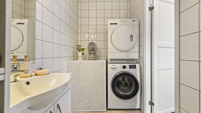 Badet er praktisk innredet med badekar, servantinnredning og opplegg for vaskemaskin.