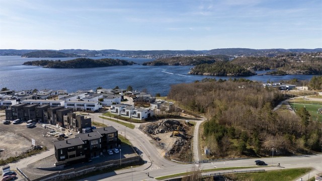 Utsikten mot Kristiansand og Korsvigfjorden. Kort vei til fotballbane og fellesområde med badeplass.