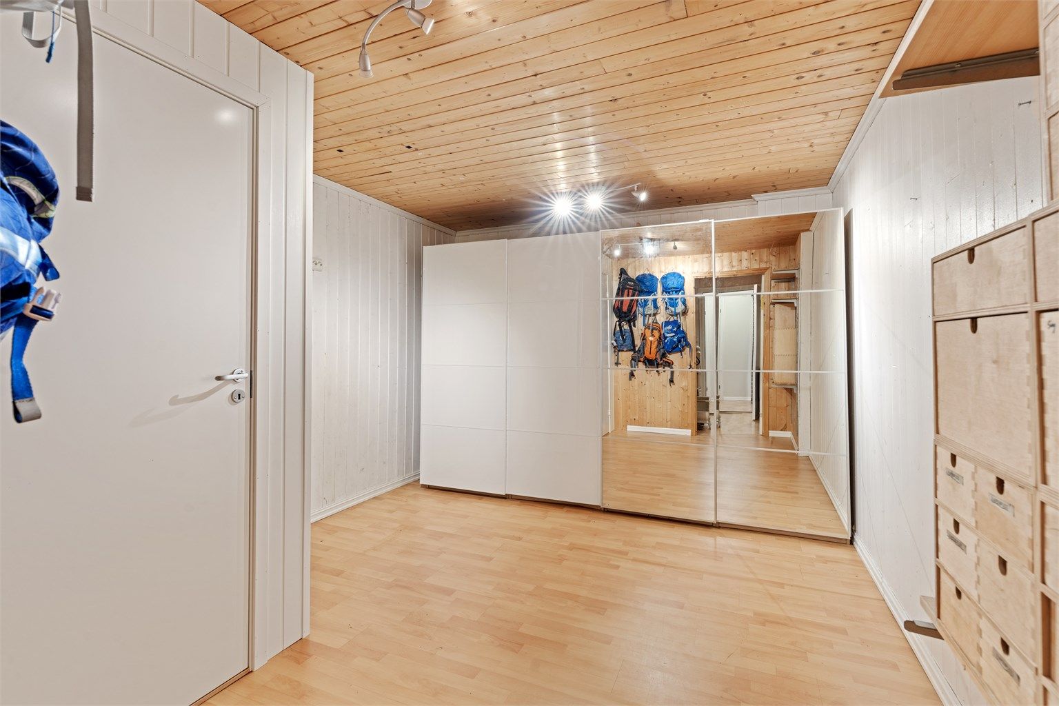 Romslig bod i underetasjen med panelte flater og rikelig med oppbevaringsplass.