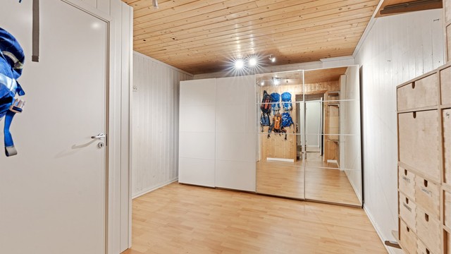 Romslig bod i underetasjen med panelte flater og rikelig med oppbevaringsplass.