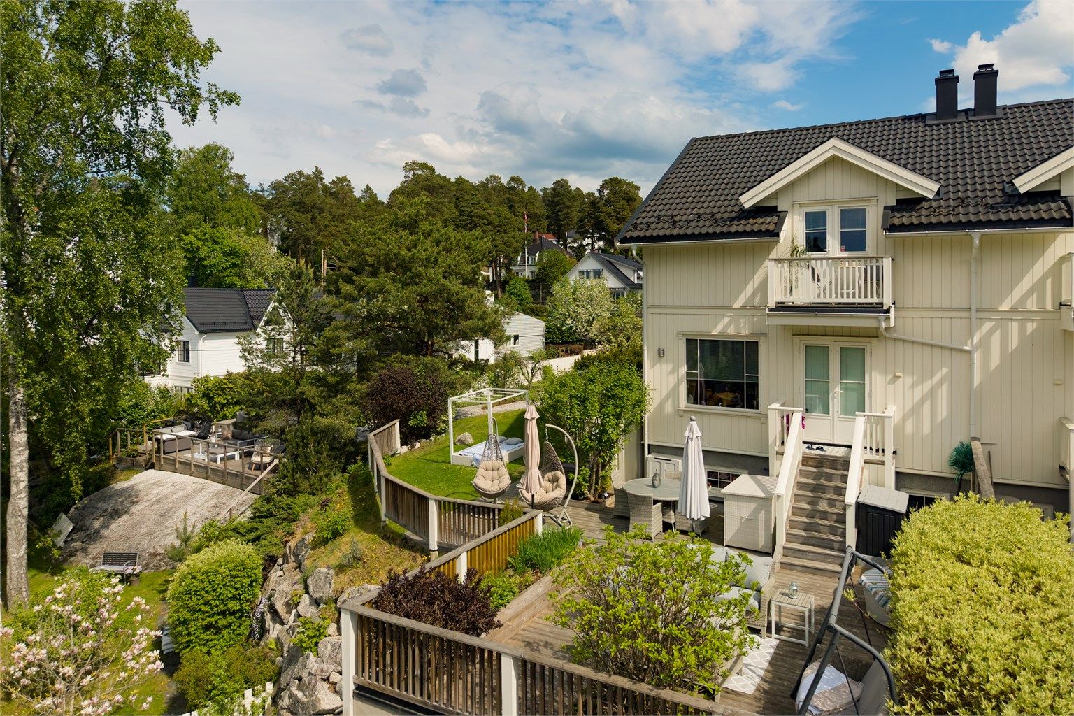 Tomten er smart utnyttet med terrasser, plattinger og hagearealer i ulike soner.