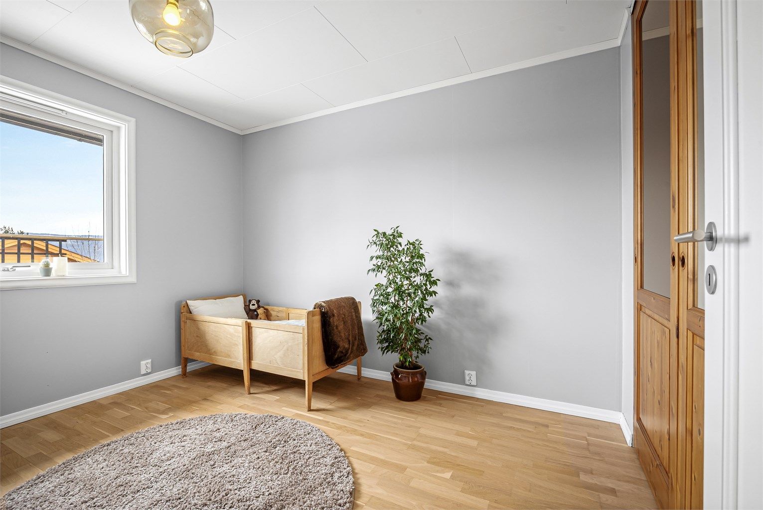 Et av boligens tre soverom, alle med malte flater og profilerte innerdører.