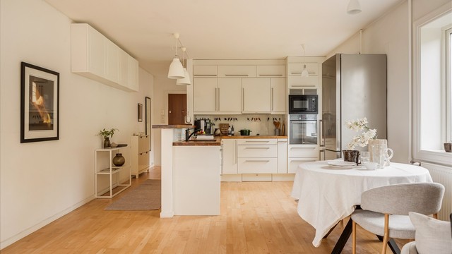 Sigdal-kjøkken med glatte fronter, benkeplate i heltre og barløsning mot spiseplassen. Foto: Martine Eren Jacobsen