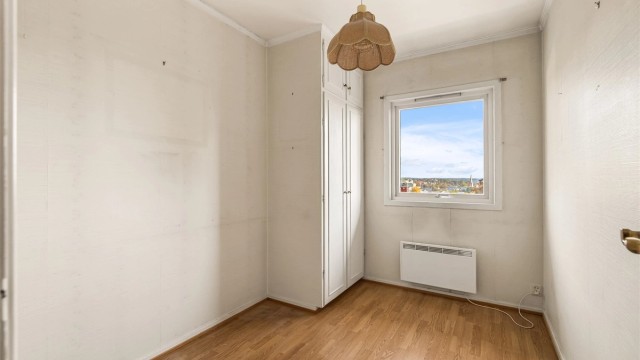 Soverom 2 med garderobeskap og utsyn over nærområdet.
