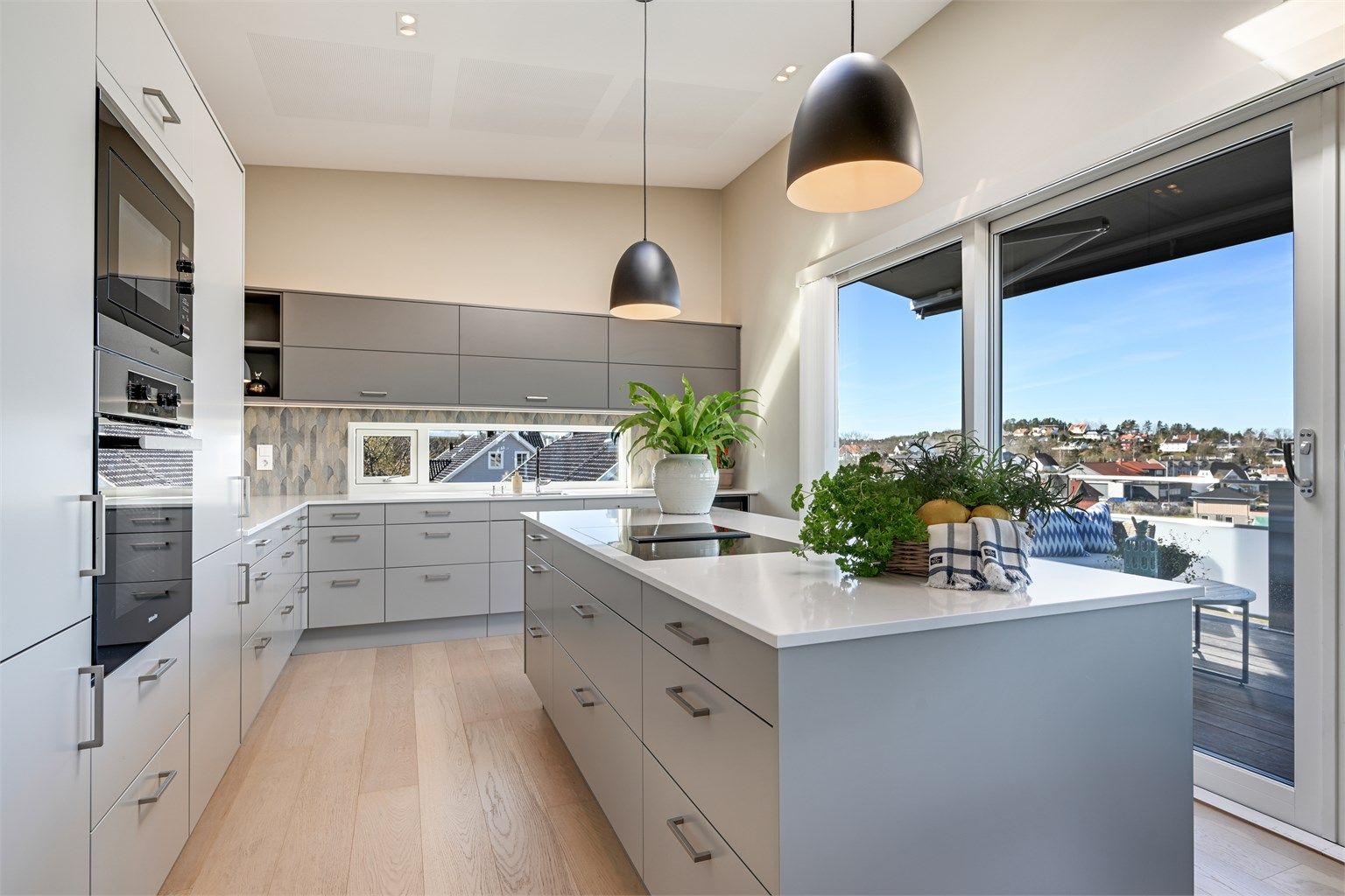 Kjøkkenet i andre etasje har en åpen løsning mot stuen og direkte utgang til en stor balkong via skyvedør i tre/aluminium.