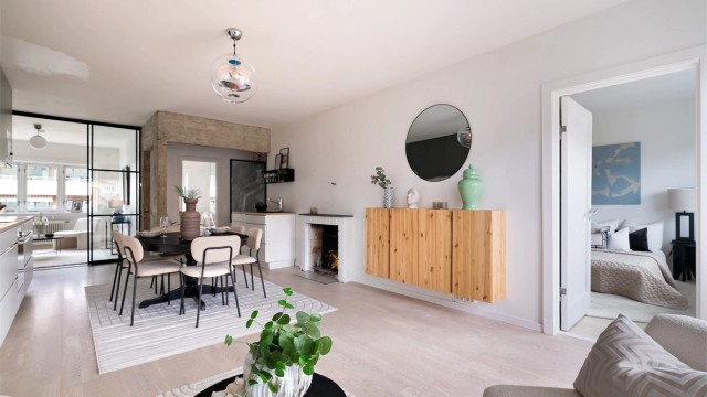 Lys og åpen stue med store vinduer og god plass til både sofa og spisebord. Her er det lett å trives.