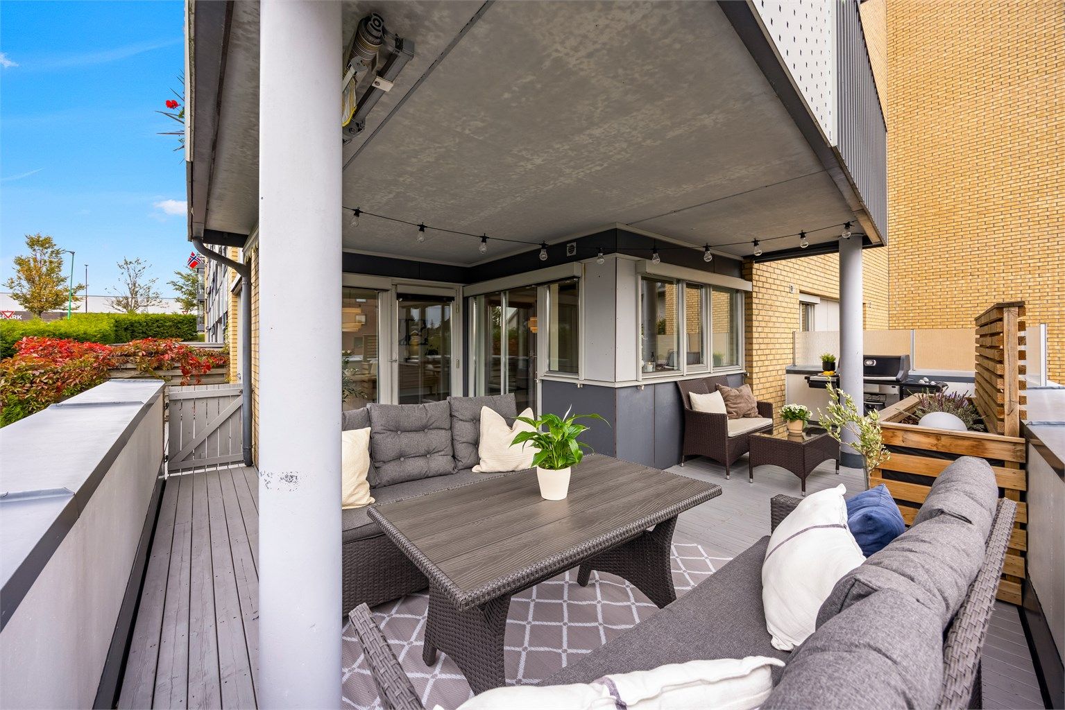 Verandaen strekker seg rundt fasaden med plass til både sofagruppe og grillhjørne.