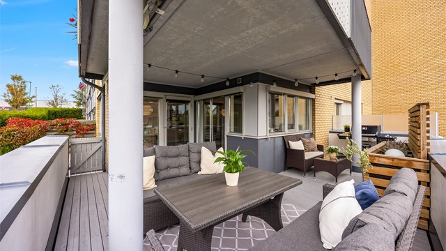 Verandaen strekker seg rundt fasaden med plass til både sofagruppe og grillhjørne.