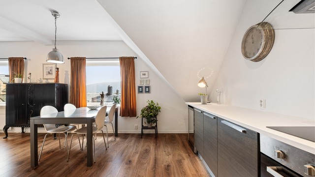 Den åpne løsningen gir et sosialt oppholdsrom. Det er lagt laminat på gulvflater og kjøkkeninnredningen er fra 2014