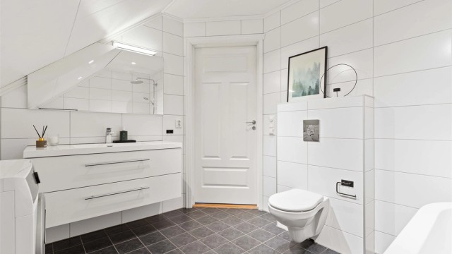 Dette badet er levert av Megaflis og har flislagte overflater og gulvvarme.