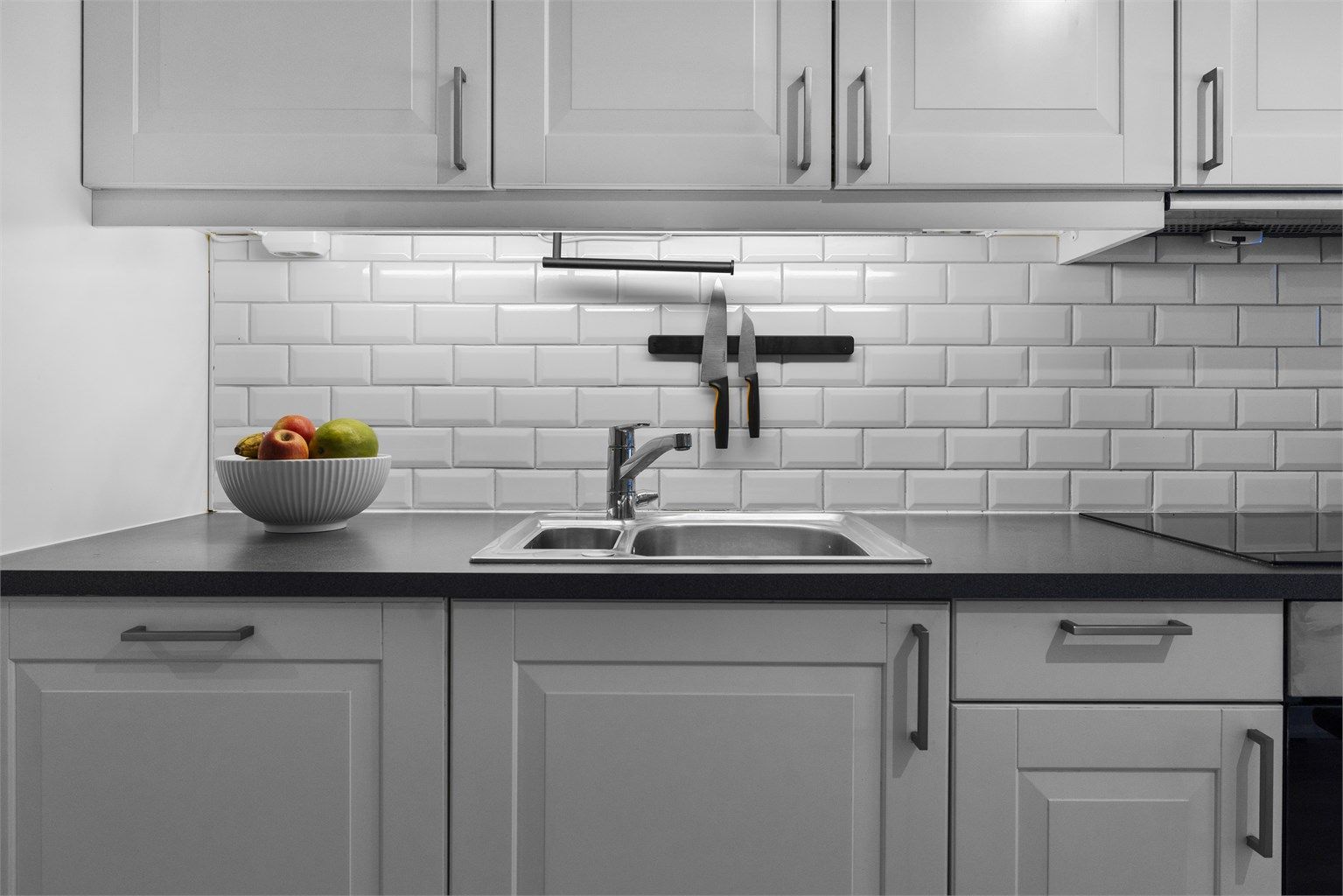 Laminert benkeplate med induksjonstopp og fliser over benken.