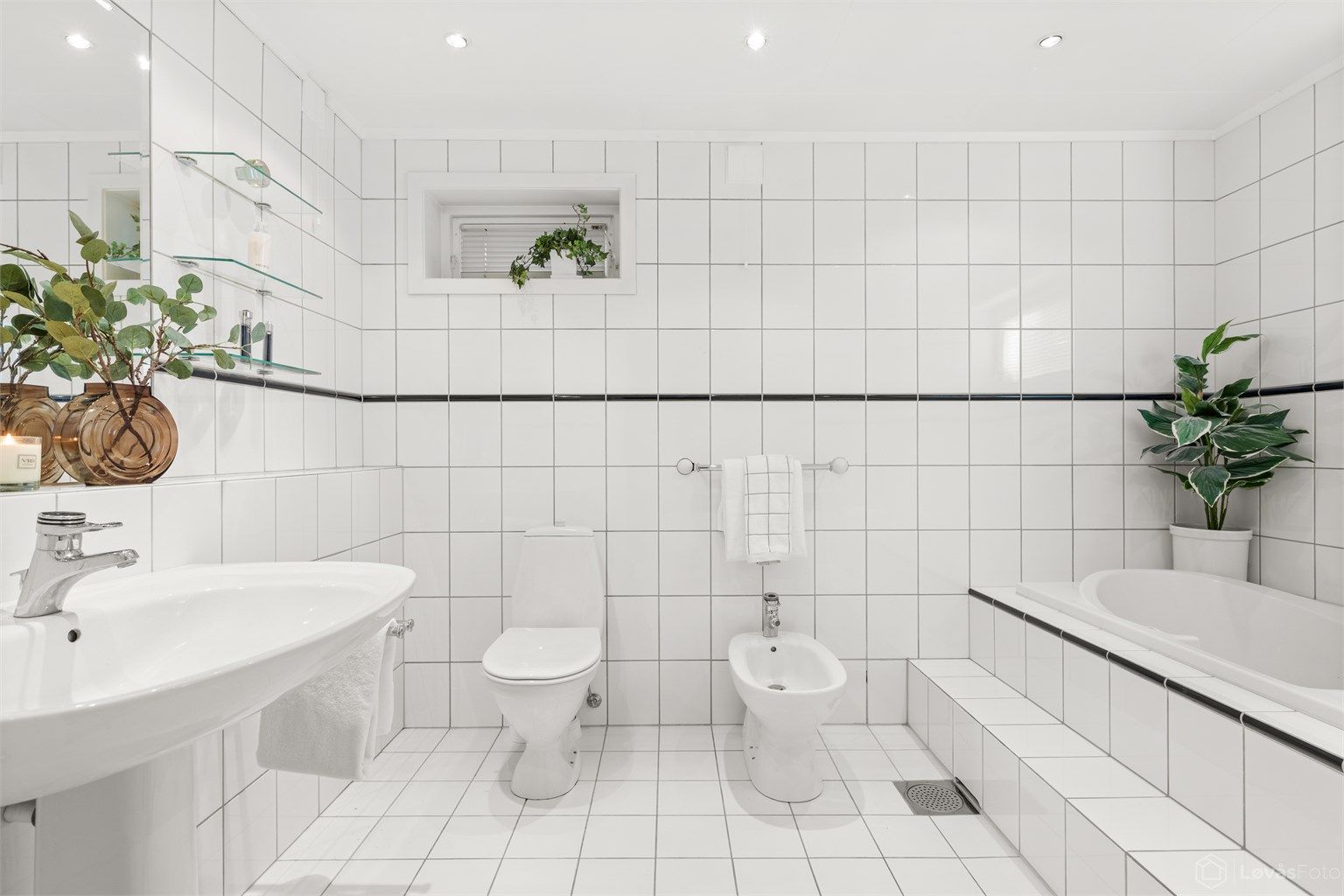 Bad 2 av 4: Et romslig og flislagt bad med gulvvarme og downlights i himling