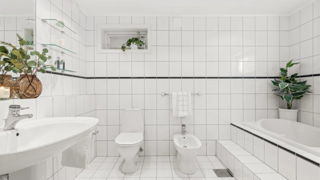 Bad 2 av 4: Et romslig og flislagt bad med gulvvarme og downlights i himling