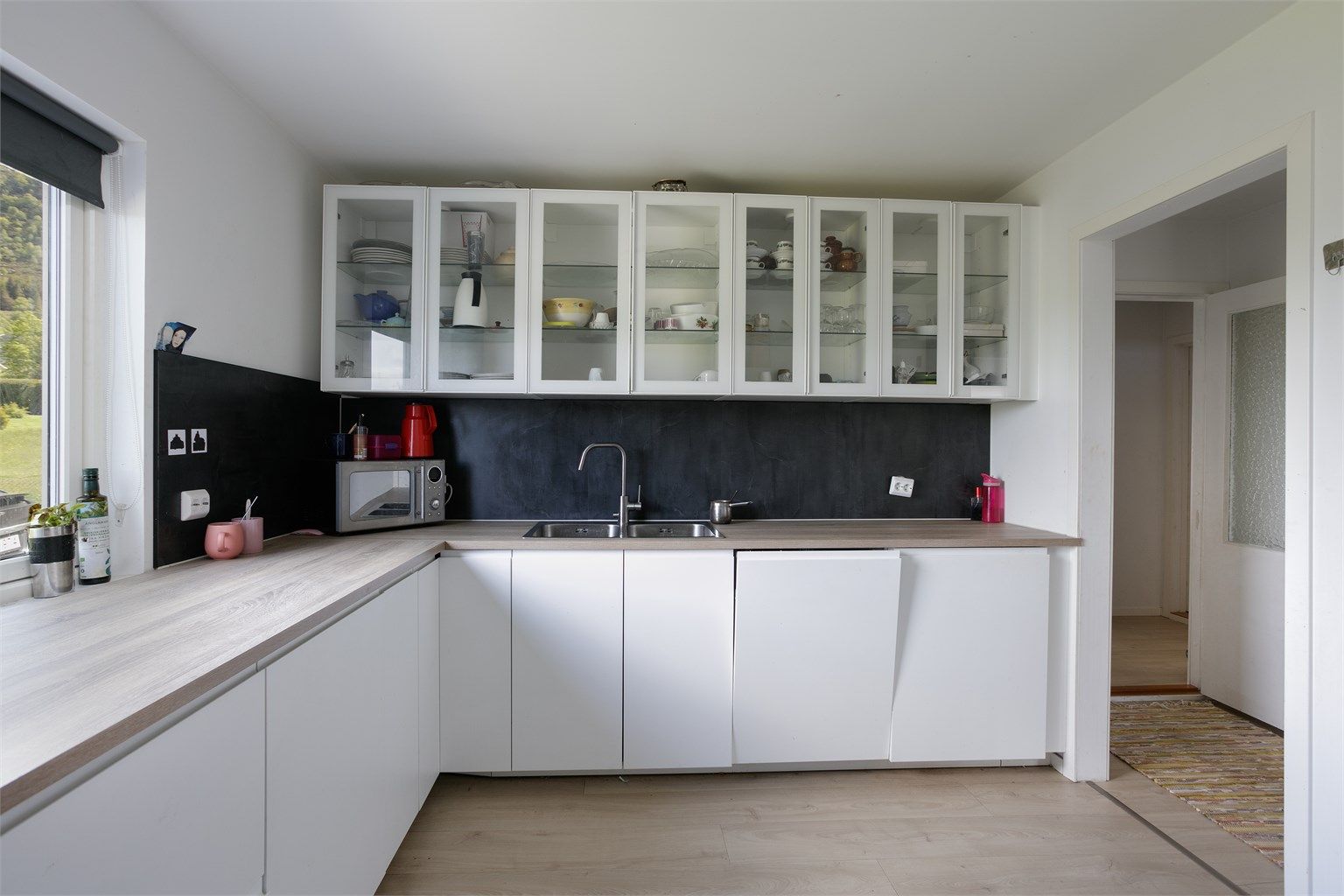 Ikea kjøkkeninnredning i hovedetasjen fra 2024 med hvite glatte fronter og benkeplate av laminat