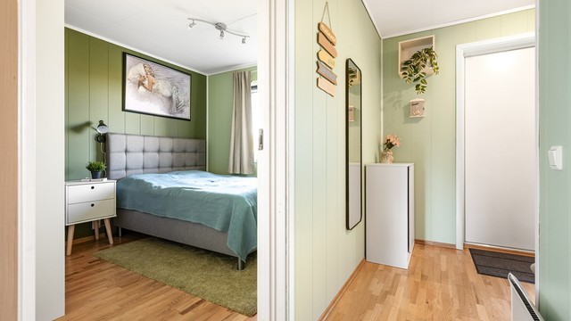 Hallen binder sammen soverom, bad og oppholdsrom på en funksjonell måte.