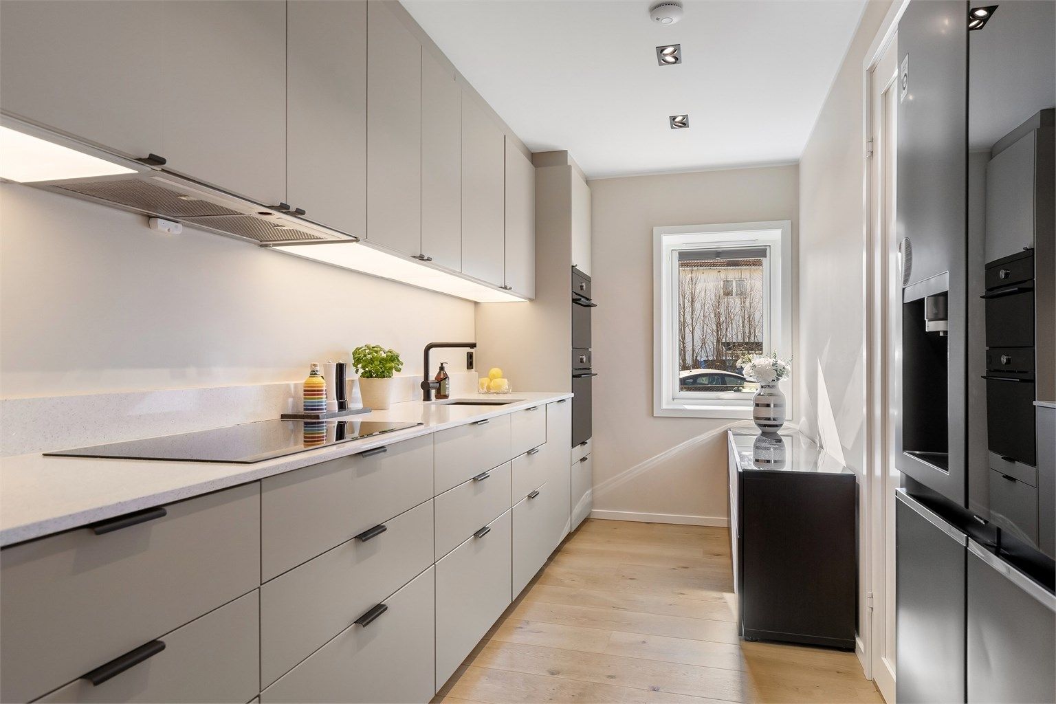 Stilrent kjøkken med glatte fronter på skap og skuffer