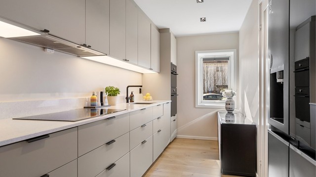 Stilrent kjøkken med glatte fronter på skap og skuffer