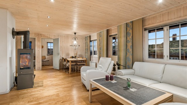 Stuen er utstyrt med en moderne peisovn med glassdør som gir god varme.
