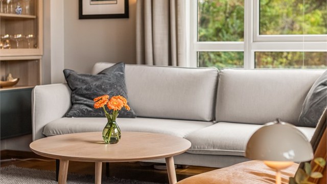 Stuen har slette, malte veggflater og store vinduer mot hagen.