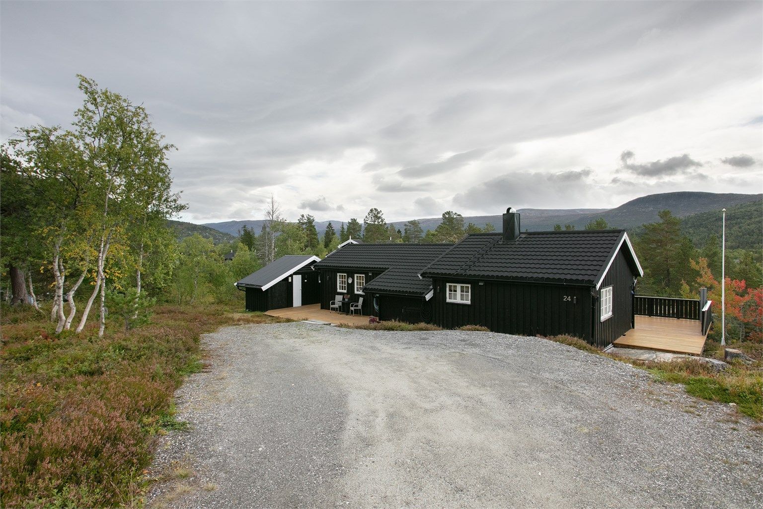Gruset innkjørsel fører helt frem til hytten med gode parkeringsforhold. 