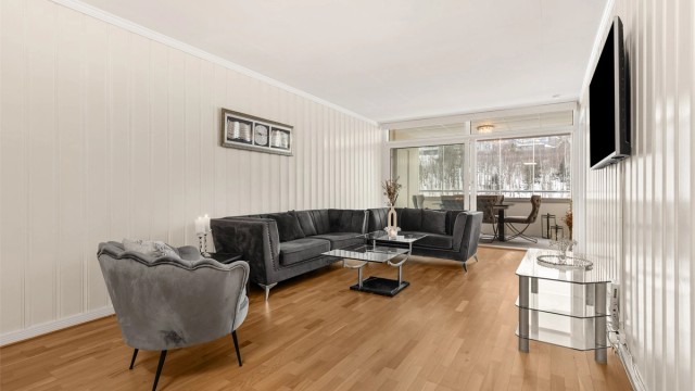 Stuen har parkett på gulvet, malt panel på veggene og god plass til en romslig sofagruppe.