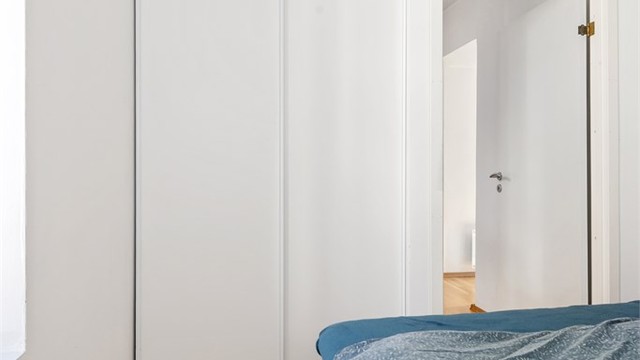 Soverommet er innredet med en praktisk skyvedørsgarderobe som gir gode oppbevaringsmuligheter.