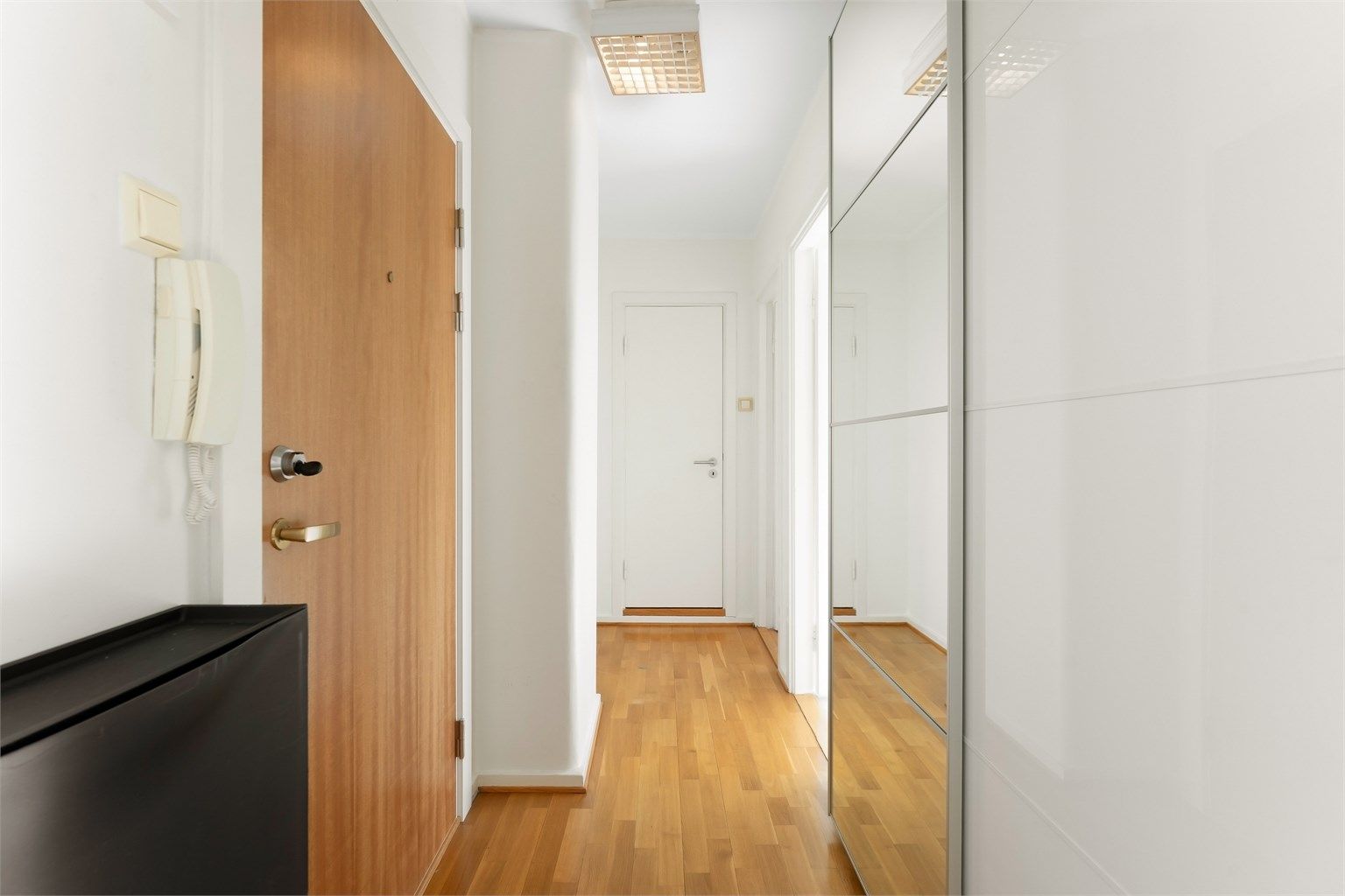 Entré med god plass til oppbevaring i en romslig skyvedørsgarderobe med speilfronter.