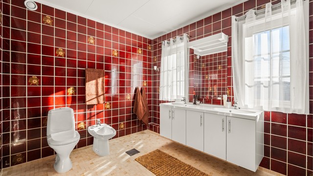 Badet er romslig, med flislagt gulv med gulvvarme, bidet og en bred servantinnredning med doble servanter.