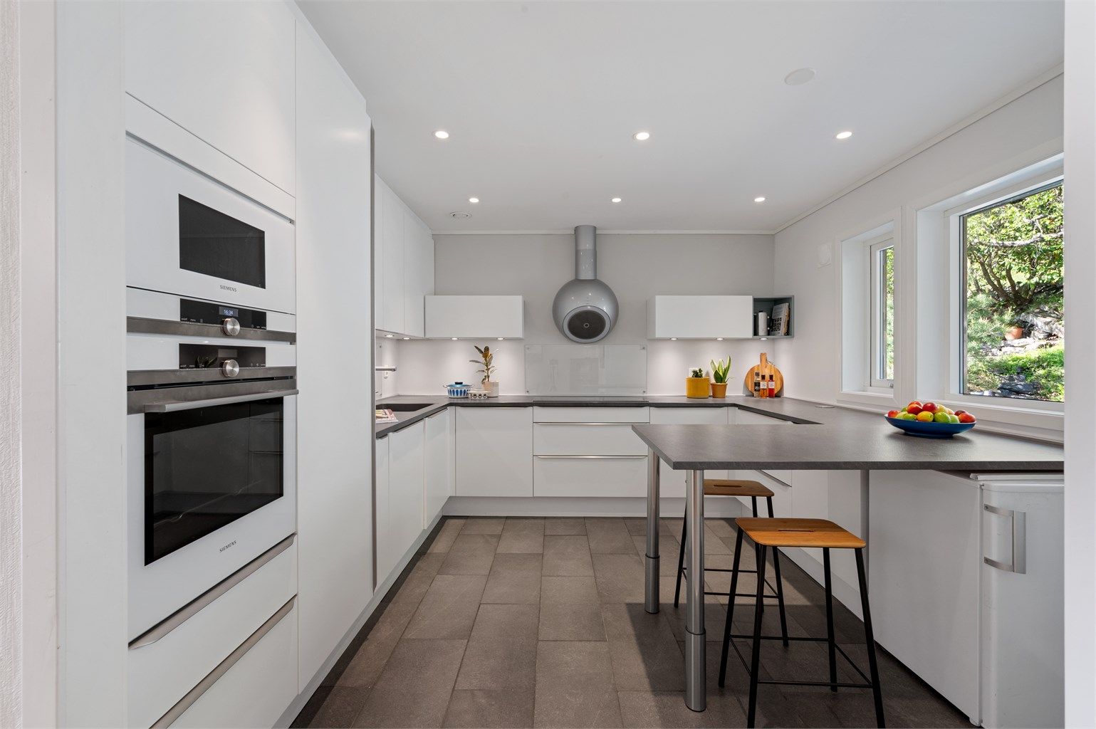 Lyst og moderne kjøkken fra 2016 med rikelig skap- og benkeplass.