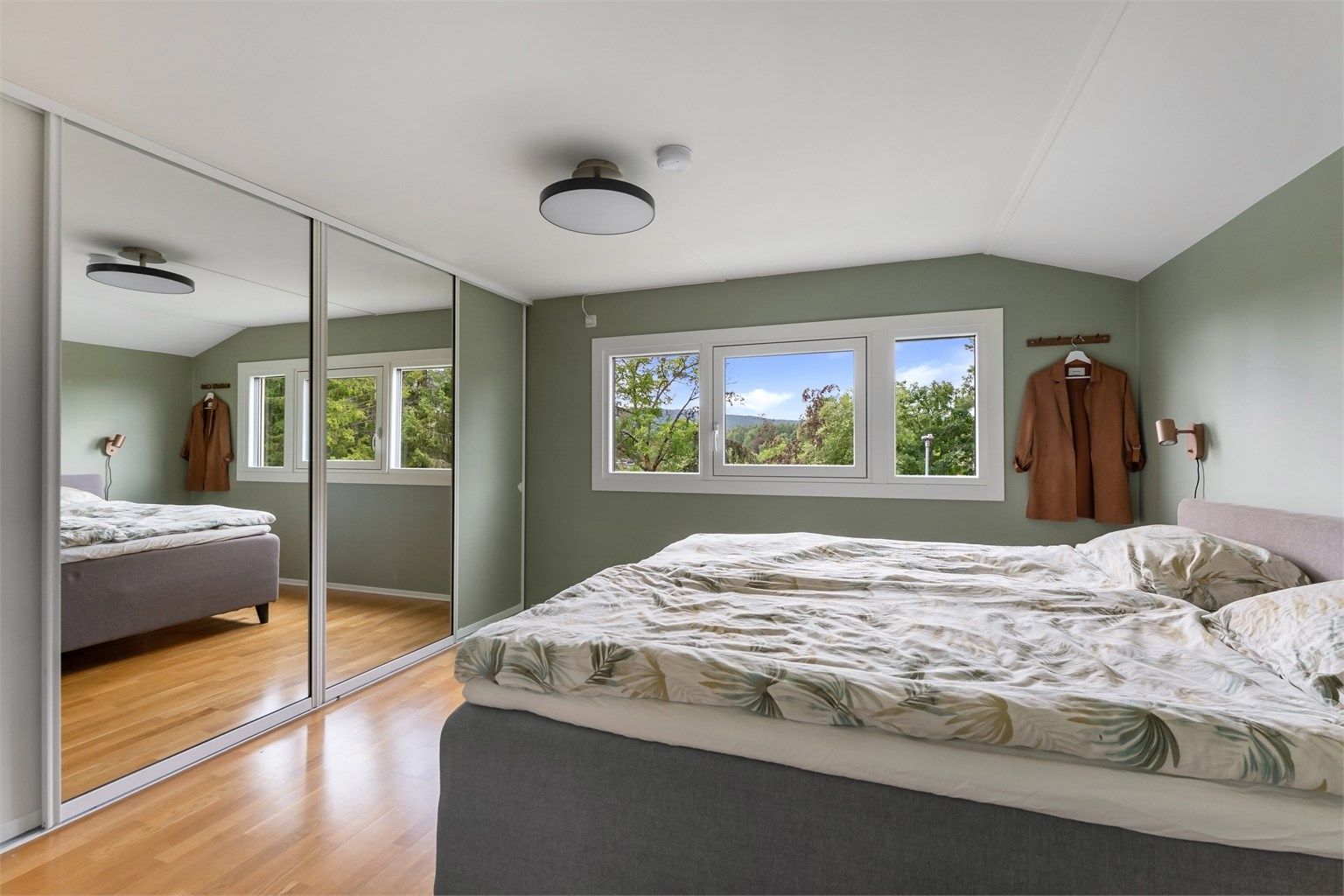 Skyvedørsgarderobe med speilfronter gir rikelig med oppbevaringsplass.