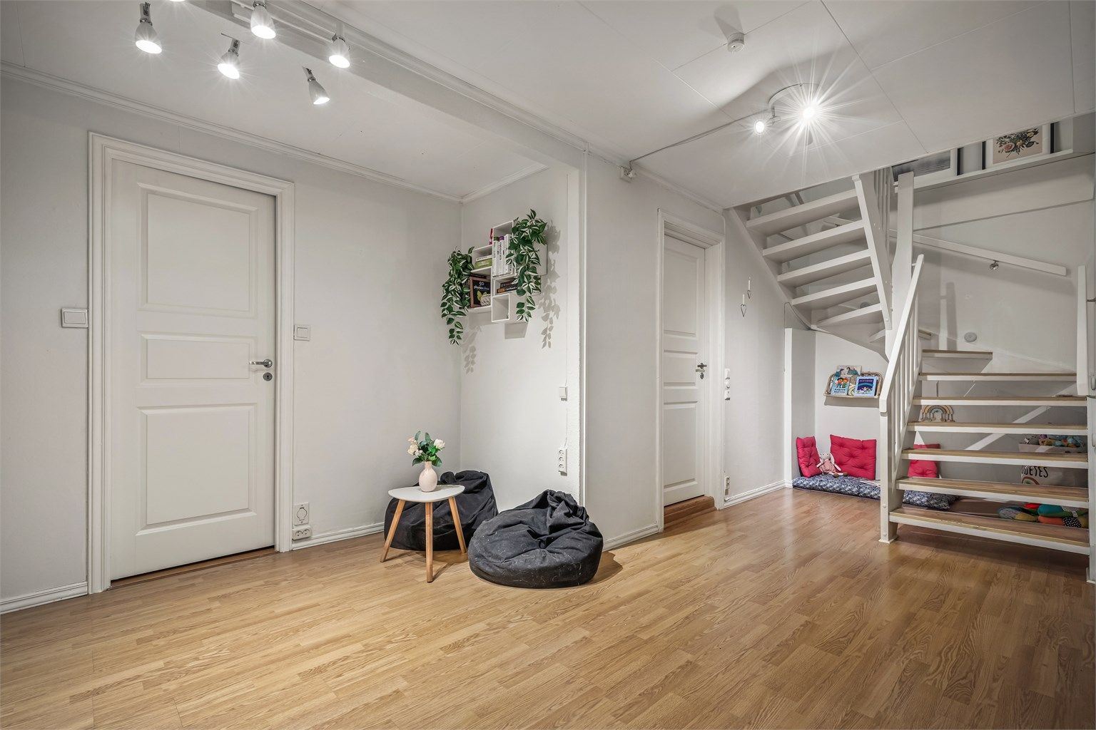 En romslig trappegang med praktisk skyvedørsgarderobe gir både plass og orden. Rommet har en åpen og luftig utforming, og selger har valgt å innrede det som en ekstra stue for barna.