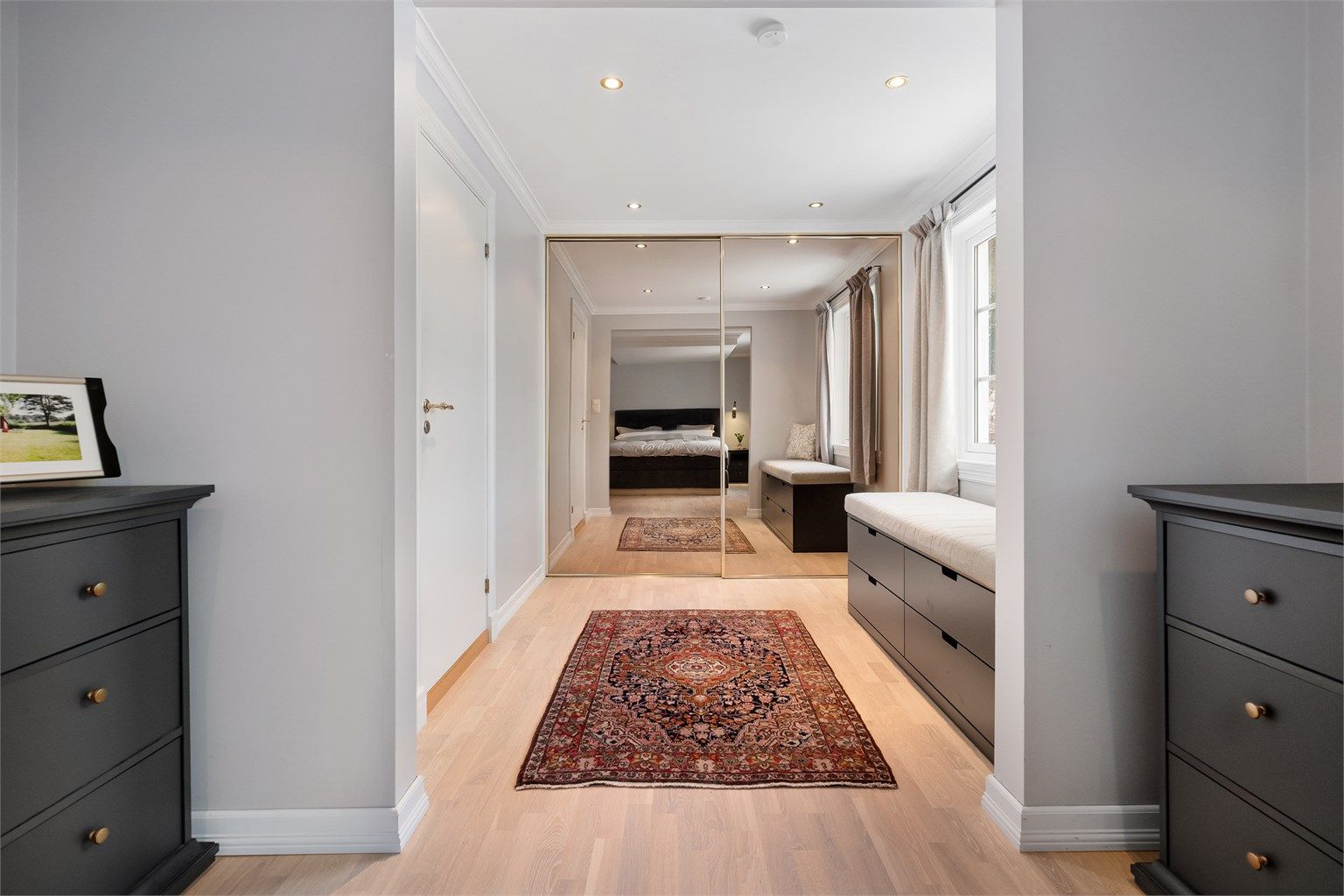 En stor skyvedørsgarderobe med speilfronter gir rikelig med oppbevaringsplass.