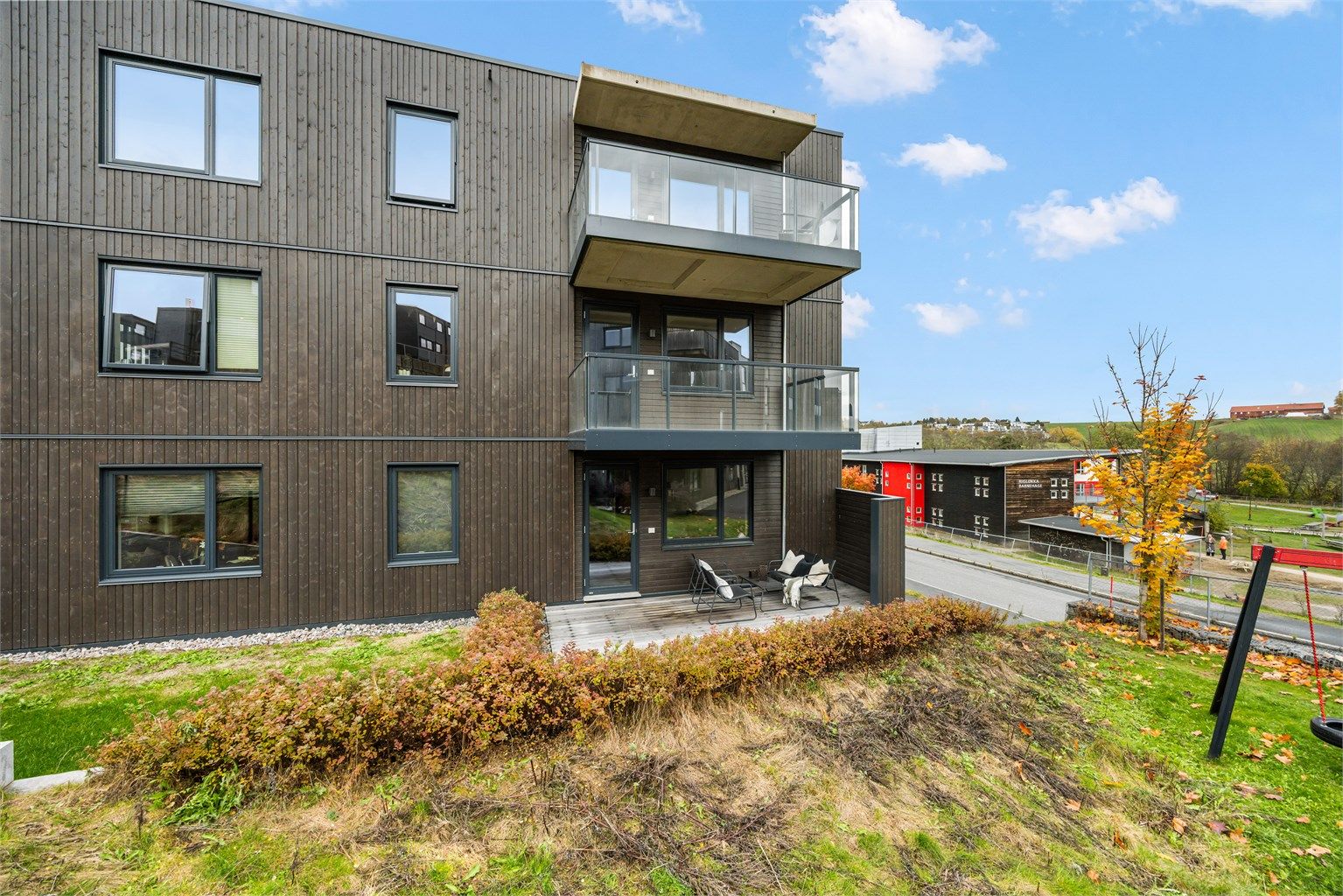 Moderne boligbygg fra 2024 med kledning i tre og utfyllende fasadeplater.