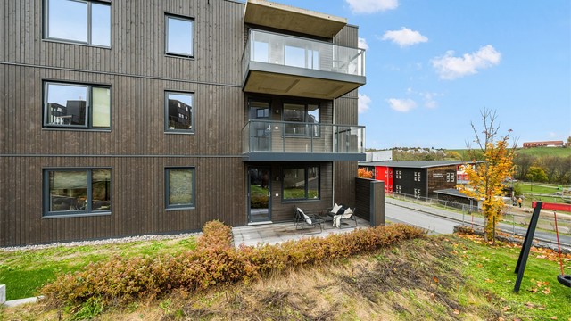 Moderne boligbygg fra 2024 med kledning i tre og utfyllende fasadeplater.