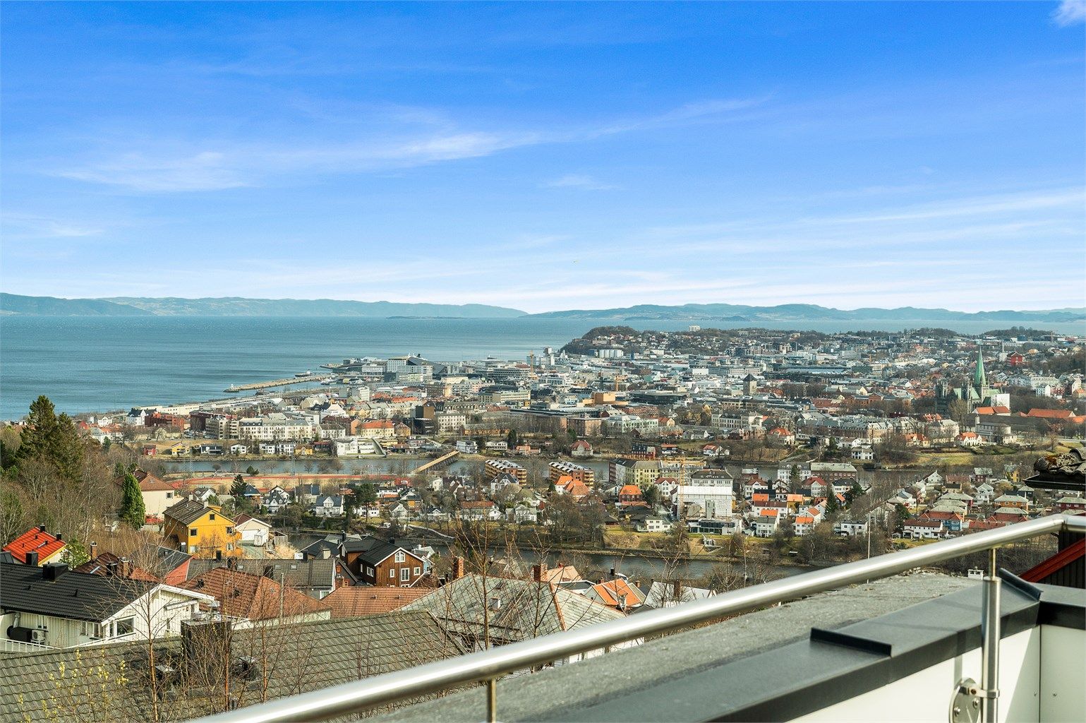 Fra takterrassen kan du nyte fantastisk utsikt over byen og fjorden – en herlig uteplass for både rolige morgener og hyggelige kvelder med gjester. 