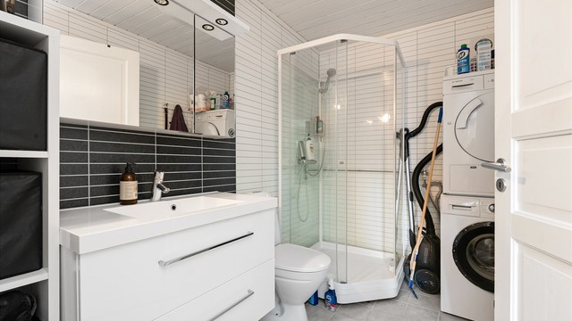 Bad i underetasjen med flislagt gulv med gulvvarme, dusjkabinett og opplegg for vaskemaskin